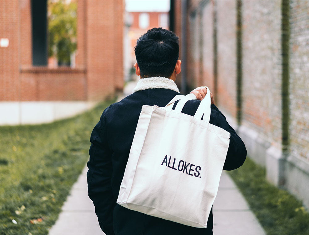 Man met totebag met opdruk ALLOKES.