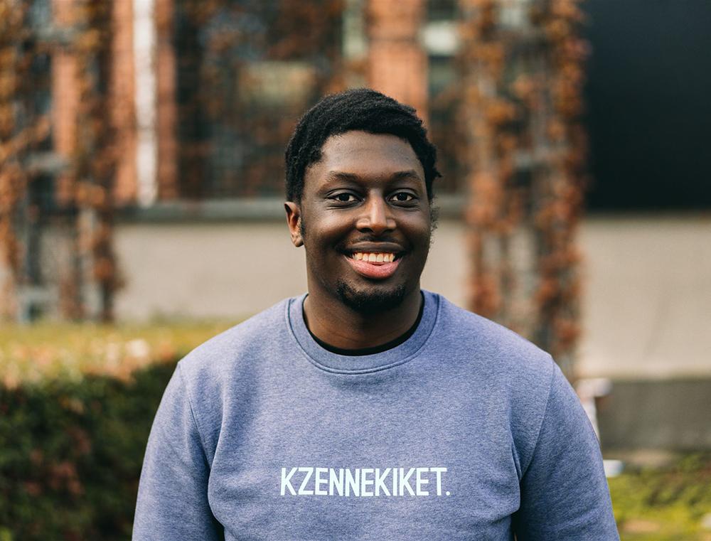 Man met blauw-grijze trui met opdruk 'KZENNEKIKET.'