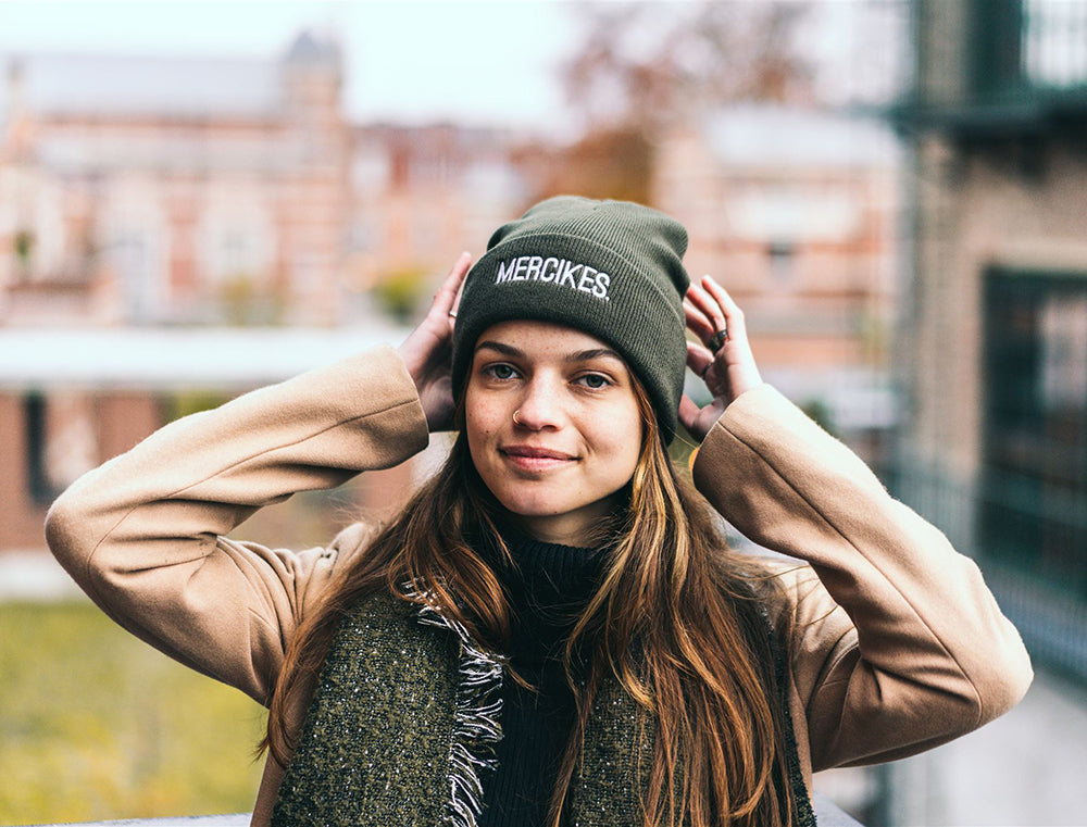 Vrouw met groene muts met opdruk MERCIKES.