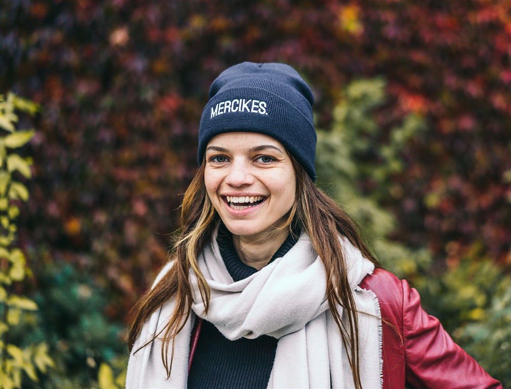 Vrouw met blauwe muts met opdruk MERCIKES.