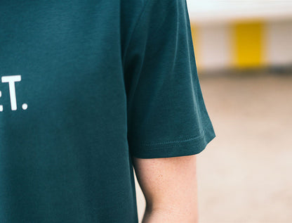 Close-up van een petrolblauwe T-shirt.