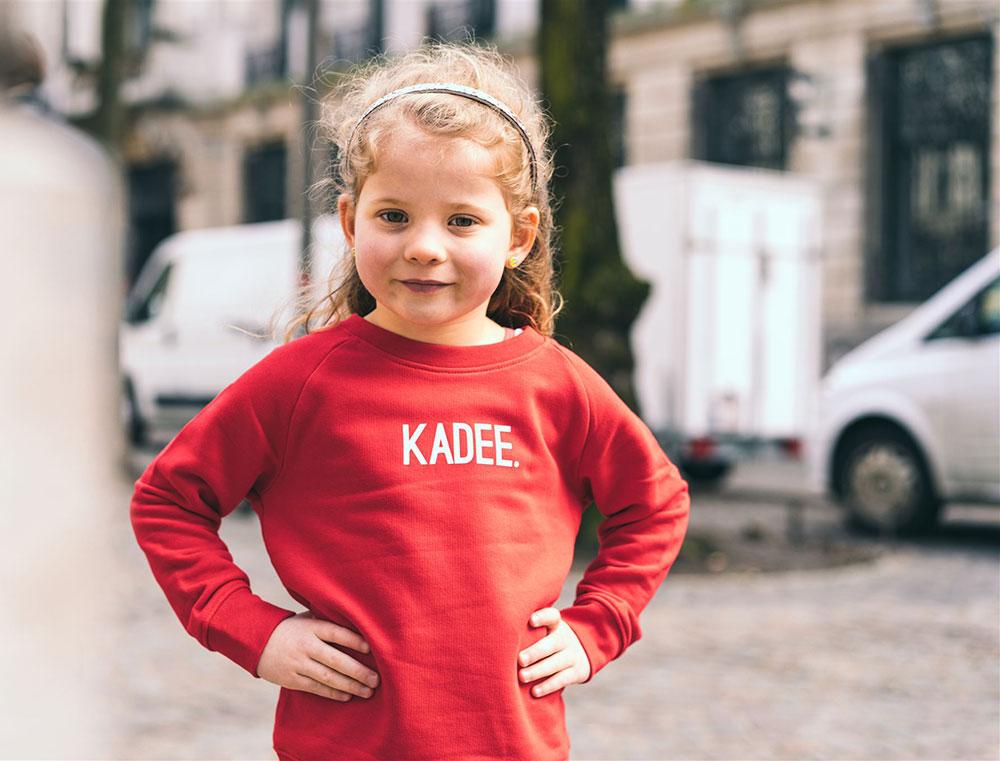 Meisje met rode trui met opdruk KADEE.