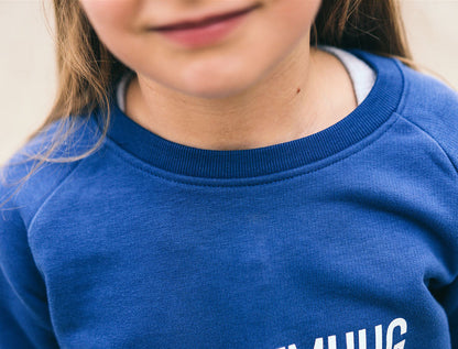 Close-up van een blauwe trui met opdruk KZENTMUUG.