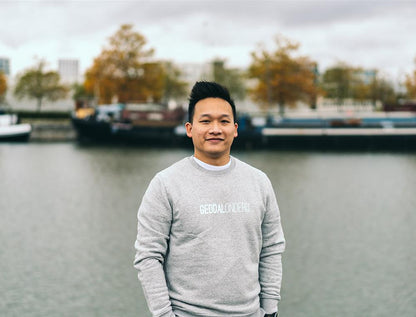 Grijze trui met opdruk GEDDALONDERD