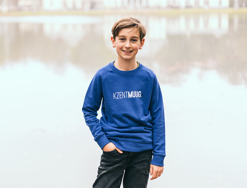 Jongen met blauwe trui met opdruk KZENTMUUG.