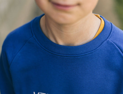 Close-up van een blauwe trui met opdruk KZENTMUUG.