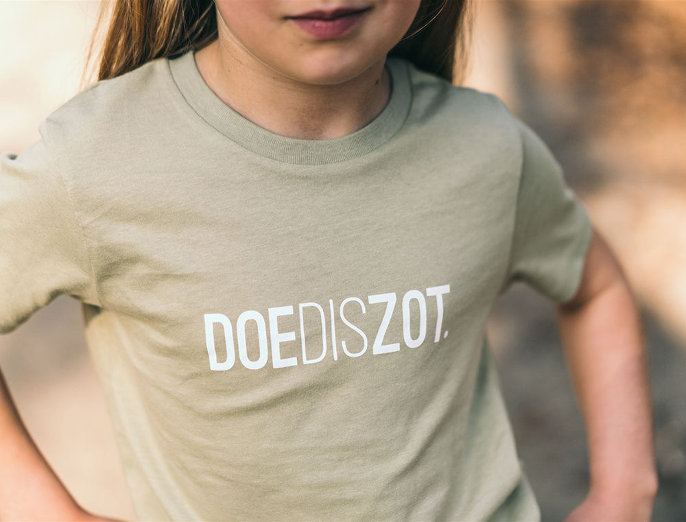 Meisje met een sage T-shirt met opdruk DOEDISZOT.