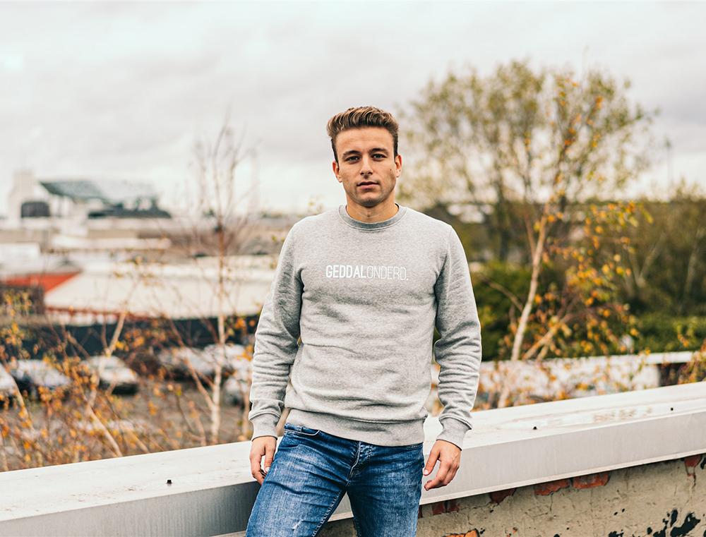 Grijze trui met opdruk GEDDALONDERD