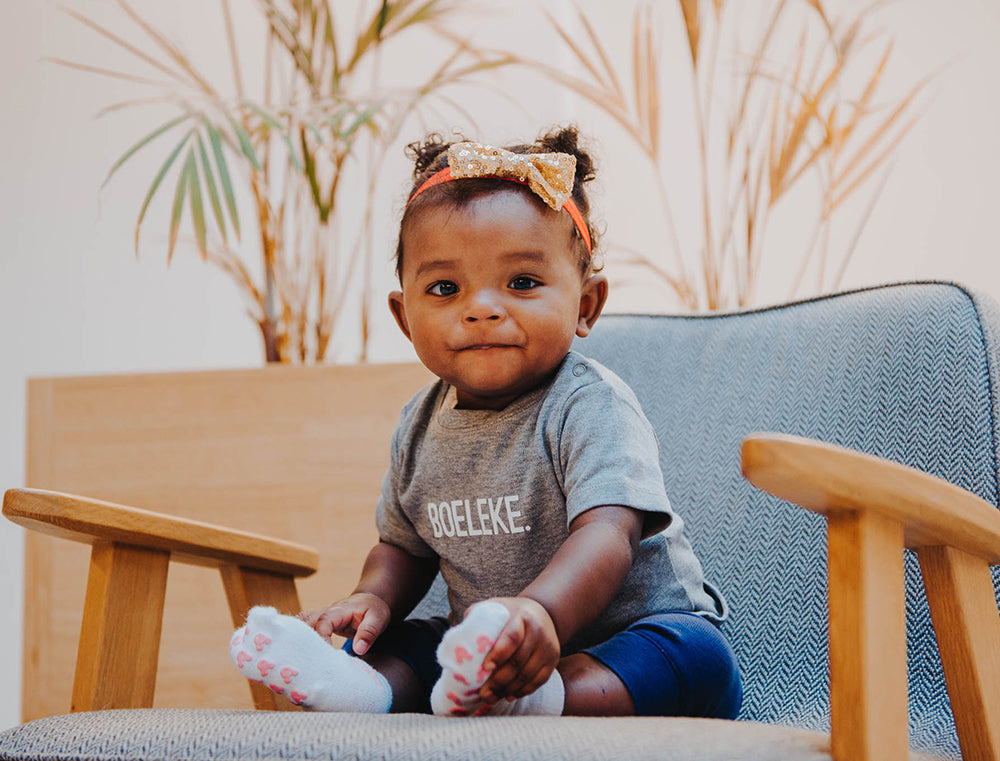 Meisje met grijze T-shirt met opdruk BOELEKE.