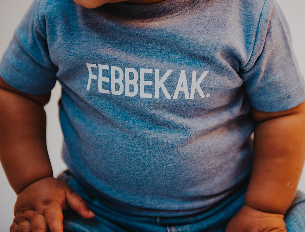 Close-up van een baby T-shirt met opdruk FEBBEKAK.
