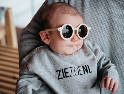 Baby met een grijze trui voor baby's met opdruk ZIEZOENI.