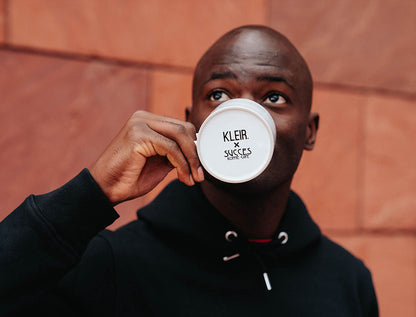Onderkant van een tas met logo van KLEIR. en Succes Koffie.