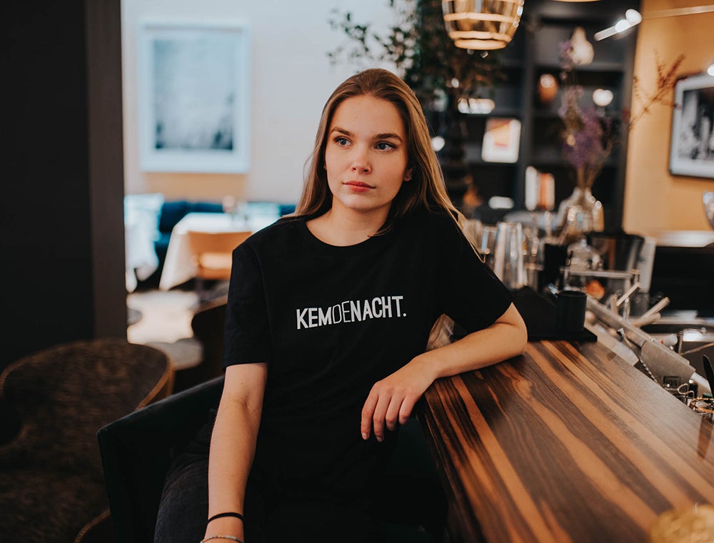 Vrouw met zwarte T-shirt met opdruk KEMDENACHT.