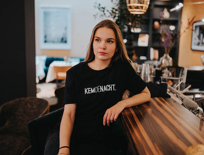 Vrouw met zwarte T-shirt met opdruk KEMDENACHT.
