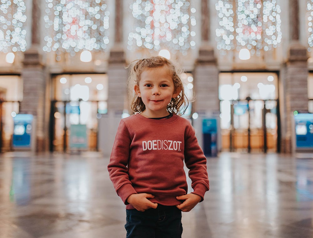 Meisje met een bordeaux trui met opdruk DOEDISZOT.