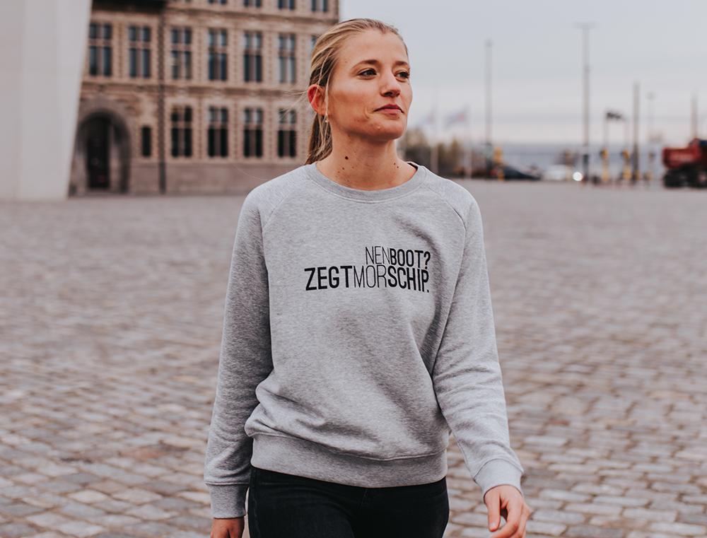 Vrouw met grijze trui met opschrift NENBOOT?ZEGTMORSCHIP.