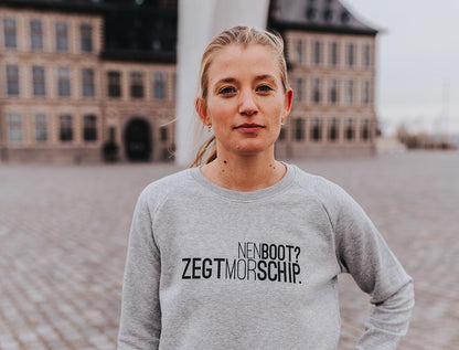 Vrouw met grijze trui met opschrift NENBOOT?ZEGTMORSCHIP.