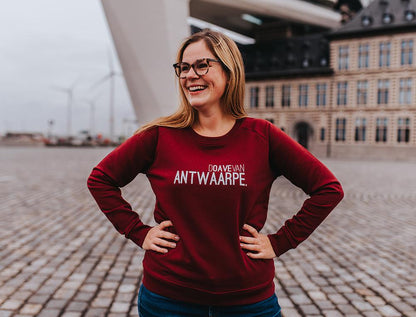 Vrouw met bordeaux trui met opschrift DOAVEVANANTWAARPE.