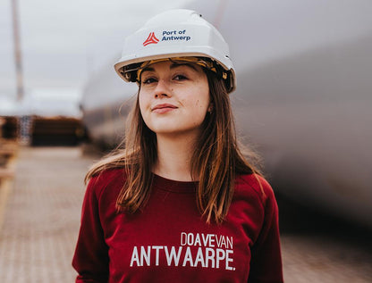 Vrouw met bordeaux trui met opschrift DOAVEVANANTWAARPE.