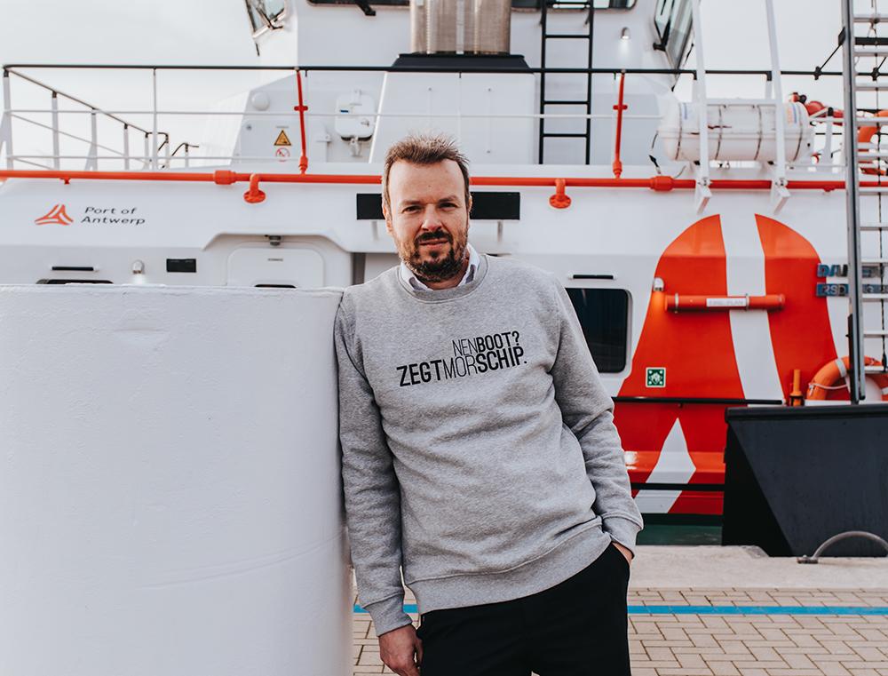 Man met grijze trui met opschrift NENBOOT?ZEGTMORSCHIP.
