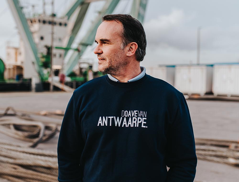 Man met blauwe trui met opschrift DOAVEVANANTWAARPE.