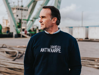 Man met blauwe trui met opschrift DOAVEVANANTWAARPE.