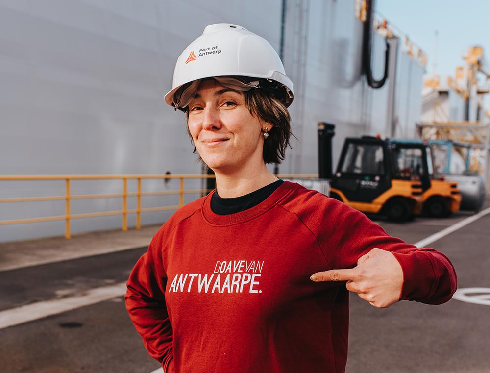 Vrouw met bordeaux trui met opschrift DOAVEVANANTWAARPE.