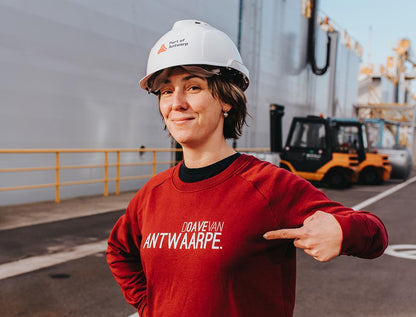 Vrouw met bordeaux trui met opschrift DOAVEVANANTWAARPE.