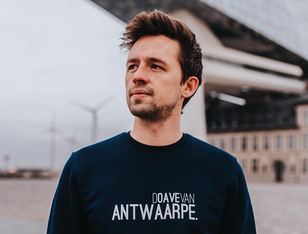 Man met blauwe trui met opschrift DOAVEVANANTWAARPE.