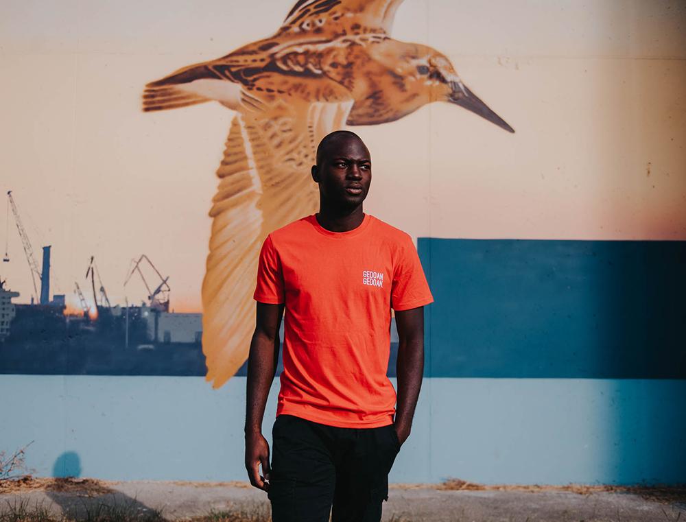 Man met rode T-shirt met opdruk GEDOANGEDOAN.