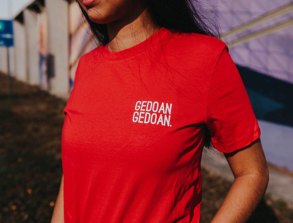 Vrouw met rode T-shirt met opdruk GEDOANGEDOAN.