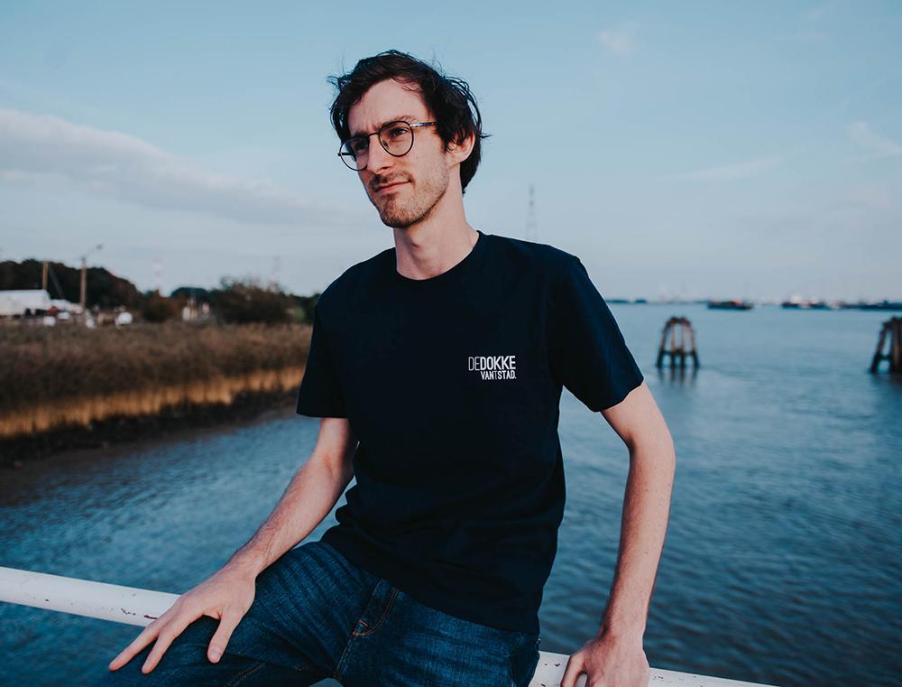Man met blauwe T-shirt met opdruk DEDOKKEVANTSTAD.