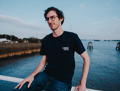 Man met blauwe T-shirt met opdruk DEDOKKEVANTSTAD.