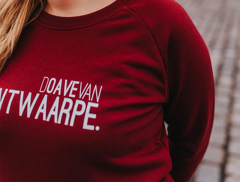 Close-up van bordeaux trui met opdruk DOAVEVANANTWAARPE.